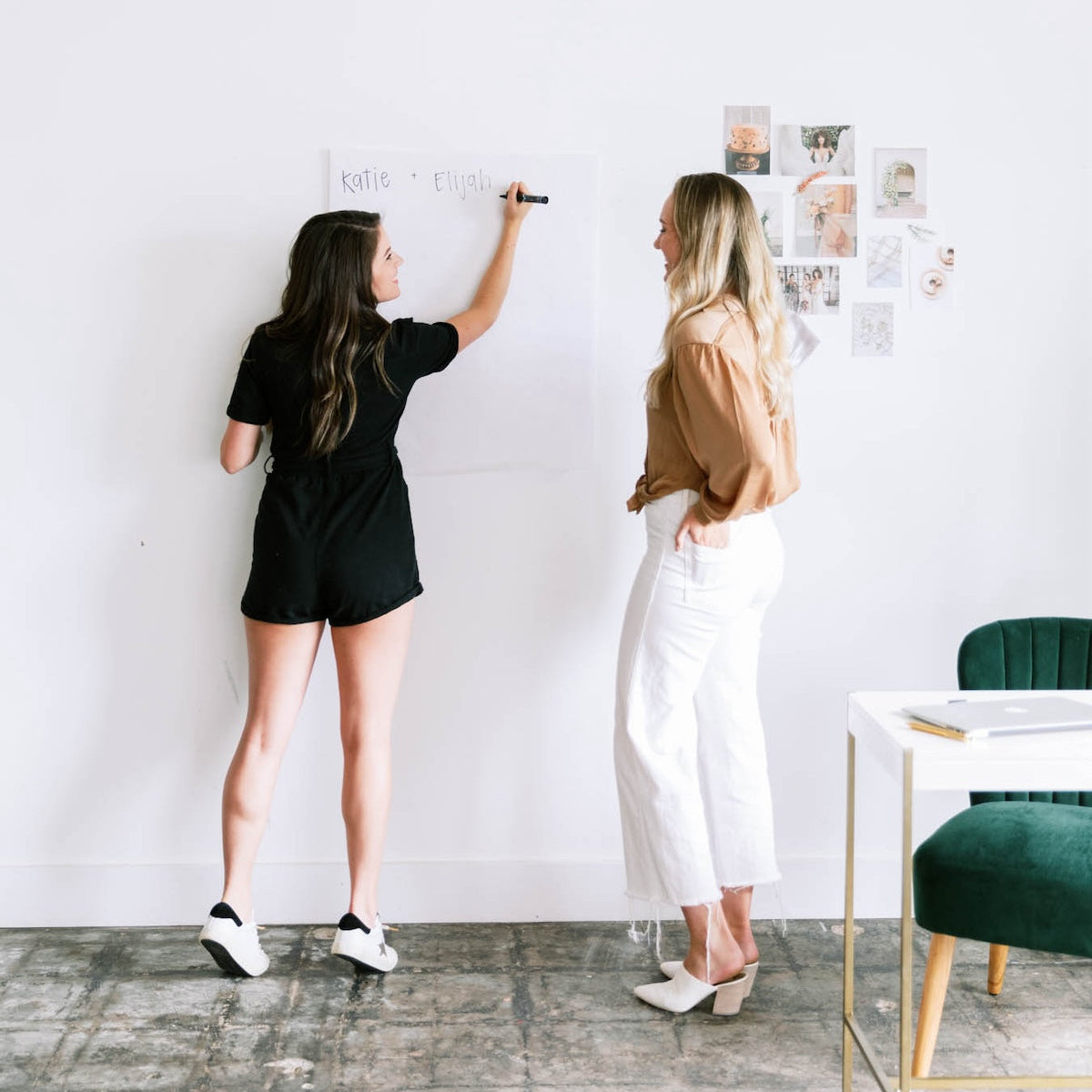 Two women at mastermind, brainstorming strategy on a whiteboard