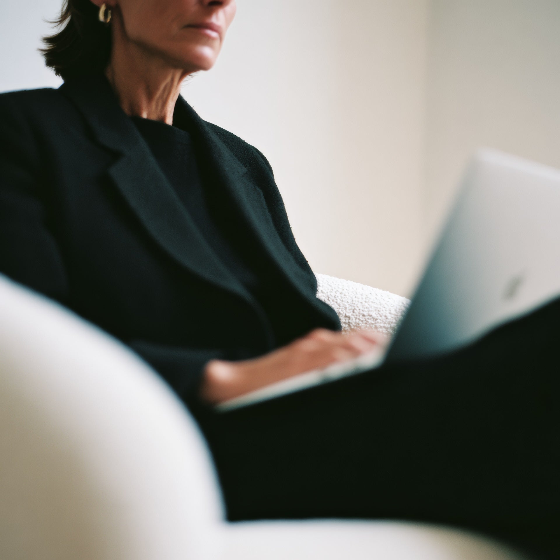 Small business owner writing a business contract on a laptop with contract documents and a notebook on the desk.