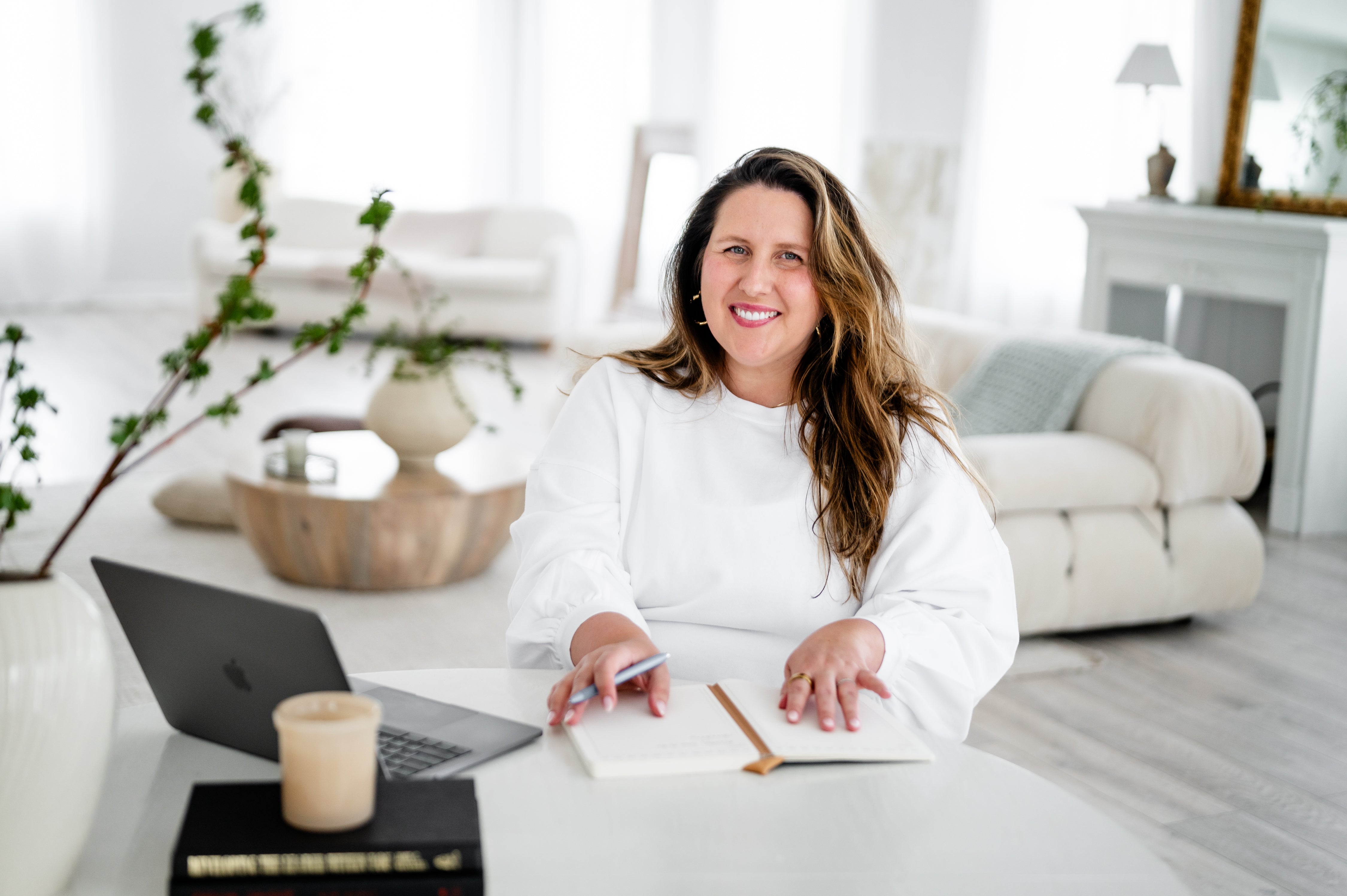 Amber, an attorney for creative entrepreneurs and service providers sitting at a table in her office drafting contract templates for creatives to protect and grow their online business.