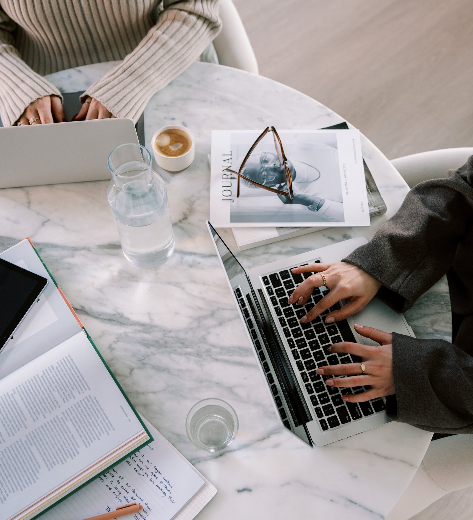 Two attorneys for creative entrepreneurs working at a desk in their office while drafting contract and legal templates for their clients and shop.