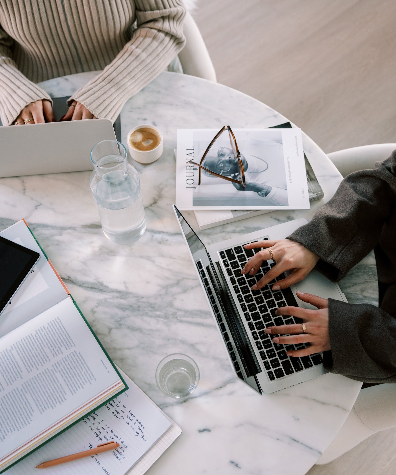 Two attorneys for creative entrepreneurs working at a desk in their office while drafting contract and legal templates for their clients and shop.