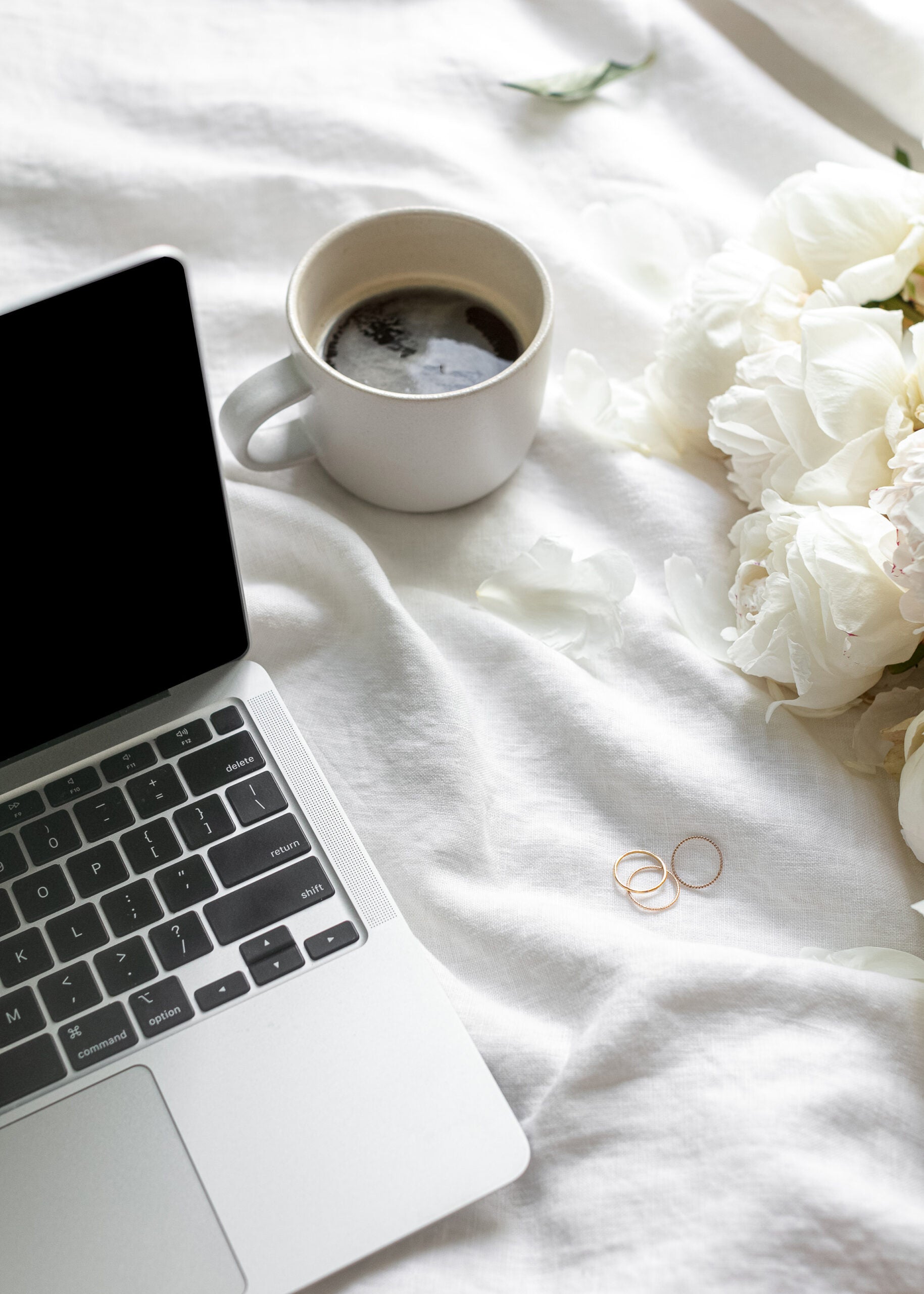 Computer of an attorney for creatives and service providers sitting on a bed while preparing to draft new contracts and legal templates.