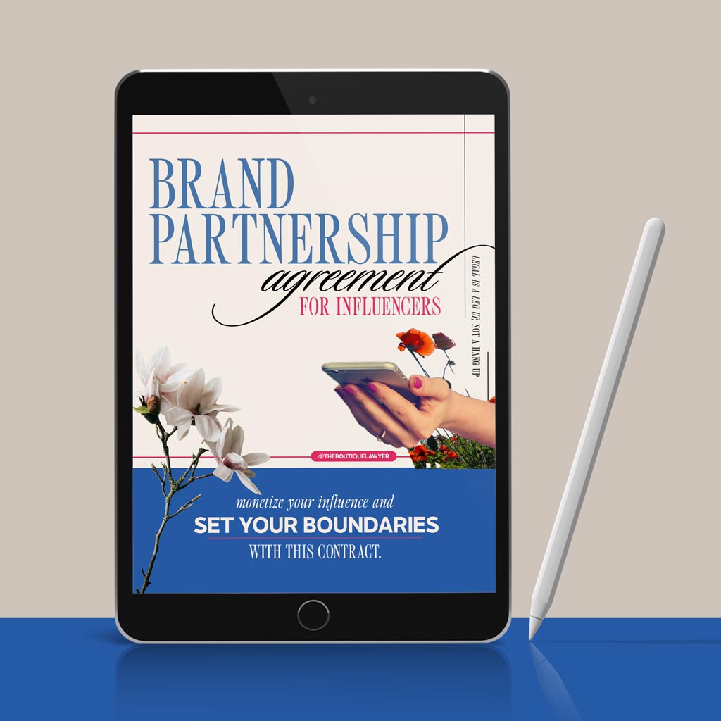 Digital tablet displaying a "Brand Partnership agreement for influencers" with flower and a hand holding a phone, stylus beside it.